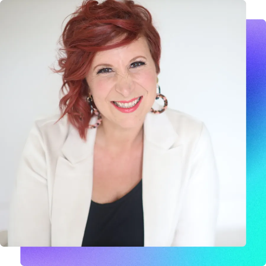 Smiling person with red hair and white jacket.